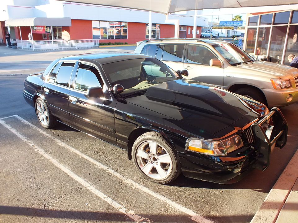 Black Crown Victoria left front three-quarter with push bar grille guard in lot