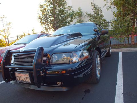 2003 Ford Crown Victoria - Front-left of a black Crown Victoria with push bar and billet grille, EVIL VIC plate shown.