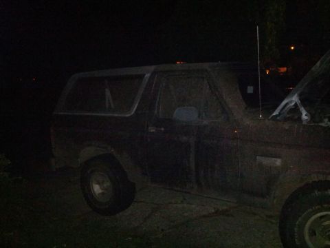 1995 Ford Bronco - A 1995 Ford Bronco is seen from the side with its hood open at night.