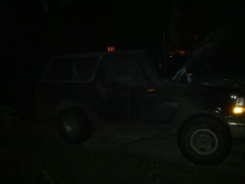 1995 Ford Bronco - This 1995 Ford Bronco is parked outside with its hood open at night.