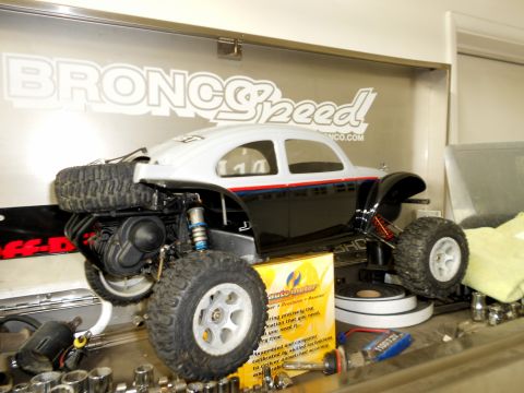 1996 Ford Bronco - An RC car with a spare tire mounted on the rear sits on a workbench with tools.