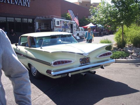 1972 Ford Ranchero - A classic 1959 Chevrolet Impala is parked outside a building with a food truck and tents in the background.