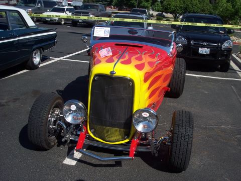 1972 Ford Ranchero - A custom hot rod with flame decals is parked in a lot with other vehicles.