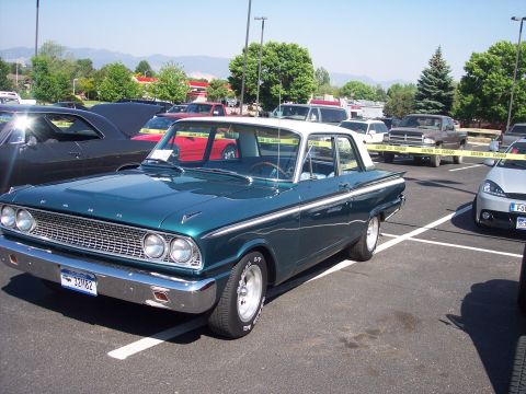 1972 Ford Ranchero - Teal and white 1961 Ford Falcon with chrome trim and custom wheels is parked in a lot.