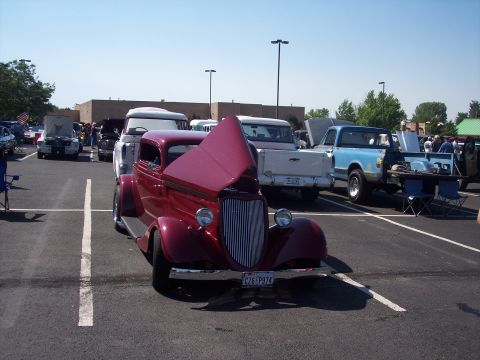 1972 Ford Ranchero - A classic maroon coupe is displayed with its hood open at an outdoor car show.