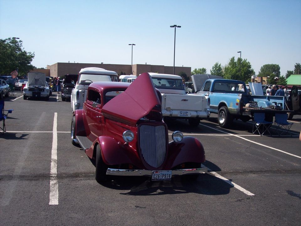 Maroon 1935 coupe with hood open, parked in a lot with other vehicles