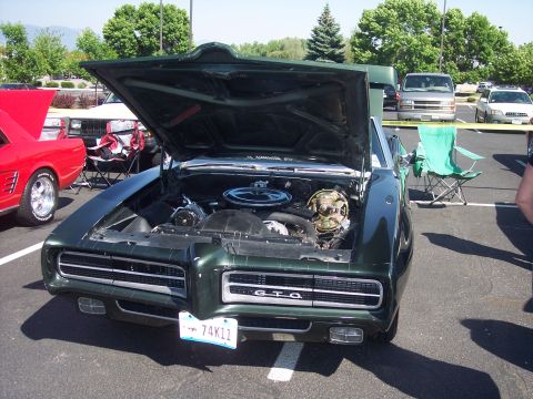 1972 Ford Ranchero - 1969 Pontiac GTO displayed with engine exposed at an outdoor event.