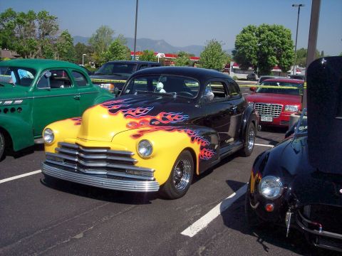 1972 Ford Ranchero - A customized hot rod with flame graphics is parked among other vehicles.