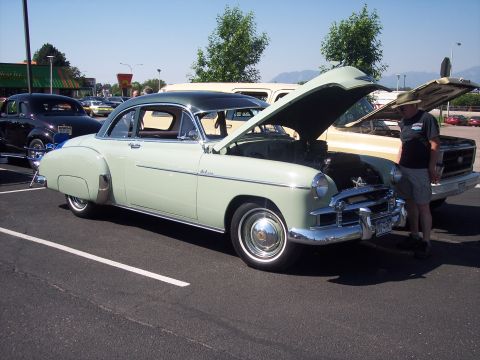 1972 Ford Ranchero - Light green 1950s Chevrolet sedan with hood open, parked next to a pickup truck.