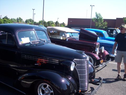1972 Ford Ranchero - Three classic cars, a black Chevrolet, a burgundy convertible, and a blue sedan, are parked in a lot.
