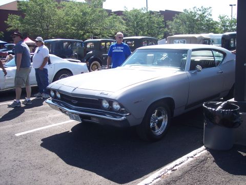 1972 Ford Ranchero - A gray 1969 Chevrolet Chevelle is parked next to other vehicles at an outdoor gathering.