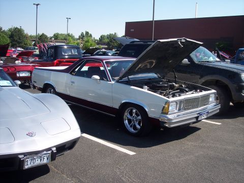 1972 Ford Ranchero - A two-tone pickup truck is displayed with its hood open at an outdoor car show.