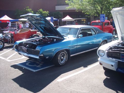 1972 Ford Ranchero - A blue classic car is parked with its hood up at an outdoor event.
