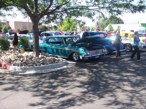 1972 Ford Ranchero - A teal 1960 Ford Falcon is displayed with its hood open at an outdoor car show.