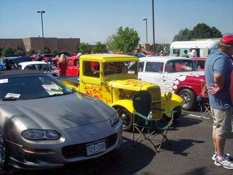 1972 Ford Ranchero - A yellow hot rod truck with flame decals is parked next to a silver convertible and a red and white station wagon.