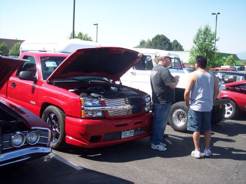 1972 Ford Ranchero - A red Chevrolet Silverado SS pickup truck is displayed with its hood open at an outdoor car show.