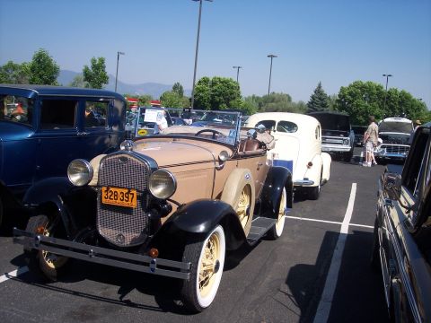 1972 Ford Ranchero - Tan 1929 Ford Model A Roadster at a car show with other vehicles present.