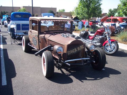 1972 Ford Ranchero - A custom-built rat rod with a weathered finish and prominent 'Black Rat' lettering on the grille is displayed at an outdoor event.