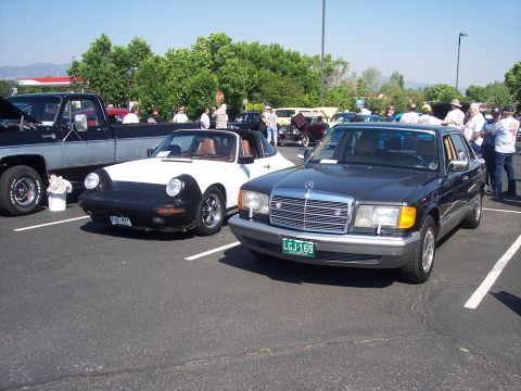 1972 Ford Ranchero - Two cars, a Mercedes-Benz sedan and a convertible sports car, are parked in a lot on a sunny day.