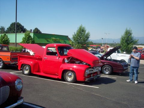 1972 Ford Ranchero - A red 1956 Ford F-100 pickup truck is displayed with its hood open at an outdoor event.