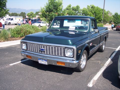 1972 Ford Ranchero - Dark green 1971 Chevrolet C10 pickup truck parked in a lot with other vehicles.