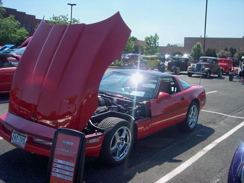 1972 Ford Ranchero - A red Chevrolet Corvette is displayed with its hood open at an outdoor car show, with several other vintage vehicles visible.