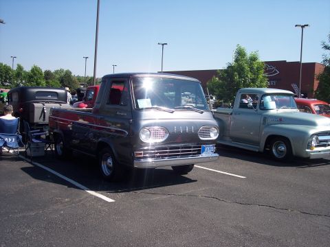 1972 Ford Ranchero - A dark gray Ford Econoline pickup truck is parked next to a light green Ford pickup truck.