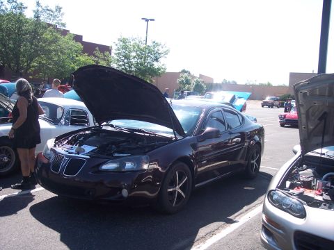 1972 Ford Ranchero - A dark red Pontiac Grand Prix is parked with its hood open at an outdoor car show.