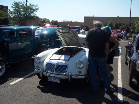 1972 Ford Ranchero - A white classic sports car is displayed with its hood open at an outdoor car show.