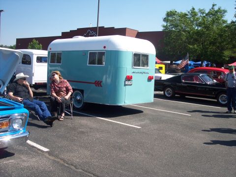 1972 Ford Ranchero - A vintage trailer and several classic cars are parked at an outdoor event on a sunny day.