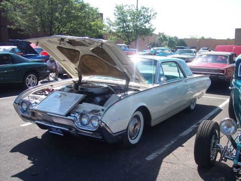 1972 Ford Ranchero - A classic white Ford Thunderbird is displayed with its hood open at an outdoor event, surrounded by other vehicles.