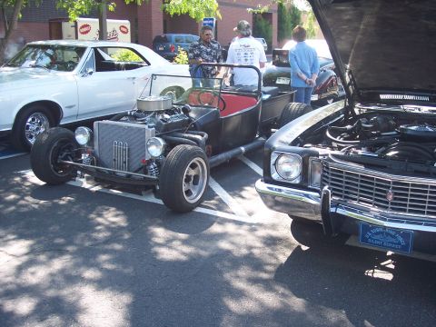 1972 Ford Ranchero - Several vehicles, including a hot rod and a classic car, are parked together in a lot on a sunny day.