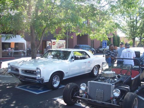 1972 Ford Ranchero - A white 1966 Pontiac GTO coupe is parked next to a hot rod at an outdoor event.