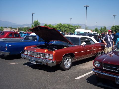 1972 Ford Ranchero - A red convertible with its hood open is parked at an outdoor event.