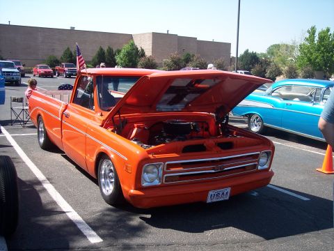 1972 Ford Ranchero - Orange 1970 Chevrolet C10 pickup truck displayed with its hood open at a car show.