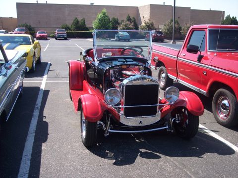 1972 Ford Ranchero - A vintage red and black convertible is parked next to a red pickup truck and a yellow car.