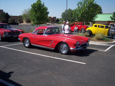 1972 Ford Ranchero - A red 1958-1962 Chevrolet Corvette is displayed at an outdoor event alongside other classic cars.