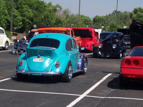 1972 Ford Ranchero - A turquoise Volkswagen Beetle is parked at a car show, surrounded by other vintage vehicles.