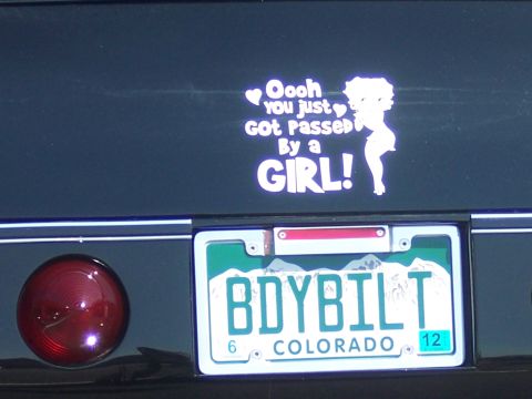 1972 Ford Ranchero - A vehicle displays a humorous sticker and a personalized license plate on its rear.