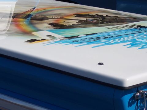 1972 Ford Ranchero - Close-up of a white fiberglass tonneau/bed cover with a rubber trim edge, laid over blue bodywork and airbrushed with a military aviation m…