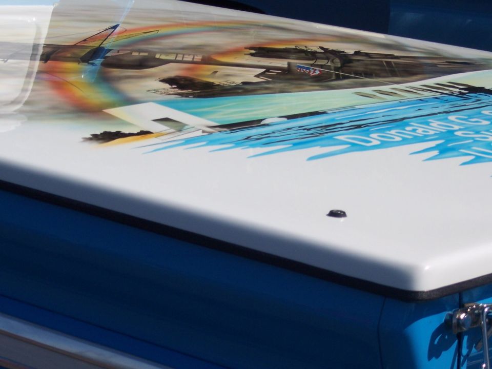 White tonneau cover on blue body with airbrushed aircraft mural and script name