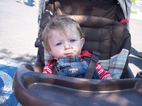1972 Ford Ranchero - A blond toddler in OshKosh denim overalls and a red shirt sits strapped in a stroller outdoors, food smudged around the mouth, with a paved…