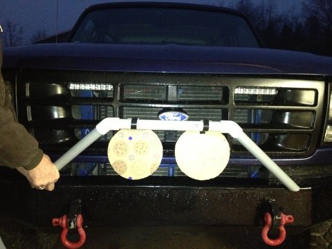 1996 Ford Bronco - A person holds a custom target rig attached to the front grille of a Ford truck, LED light bars above the grille.