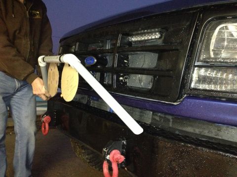 1996 Ford Bronco - Person holding a DIY target holder in front of the grille of a 1996 Ford Bronco.