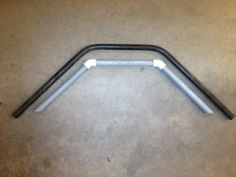1996 Ford Bronco - Two metal bars, one with PVC pipe fittings, lie on a concrete floor.
