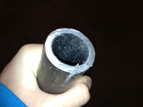 1996 Ford Bronco - A hand holds a metal pipe, revealing its hollow, dark interior.