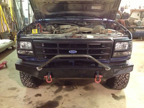1996 Ford Bronco - Front view of a 1996 Ford Bronco with its hood open, a custom bumper and off-road tires.