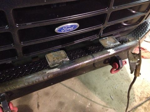 1996 Ford Bronco - Close-up of a Ford grille and bumper, showing a blue oval emblem and tow hooks.