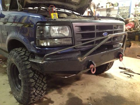 1996 Ford Bronco - Front view of a blue Ford truck with its hood up, showing an aftermarket bumper and large tires.