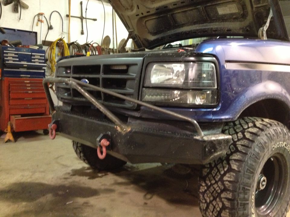 Blue Ford truck with aftermarket bumper and hood open. Visible text: SUPERMOTORS.NET